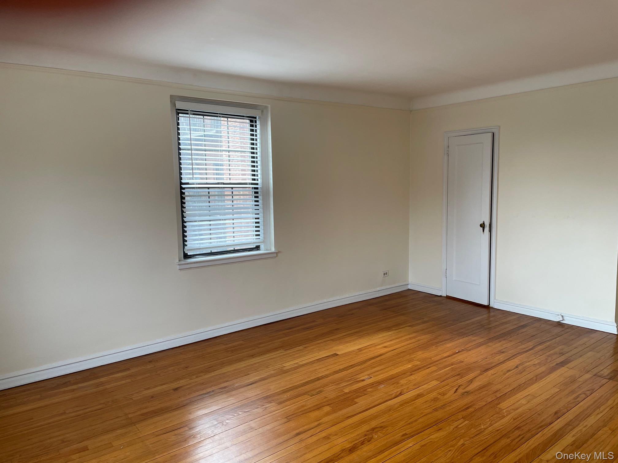 192 Garth Road, Unit 4N Scarsdale, NY 10583 - Photo 15 of 32 a view of an empty room with wooden floor and a window