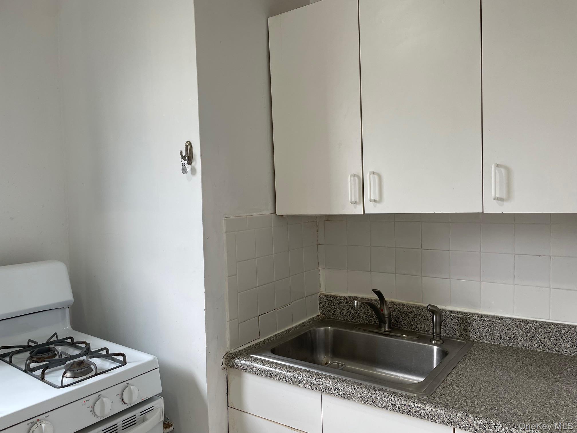 192 Garth Road, Unit 4N Scarsdale, NY 10583 - Photo 18 of 32 a kitchen with a sink a stove and cabinets