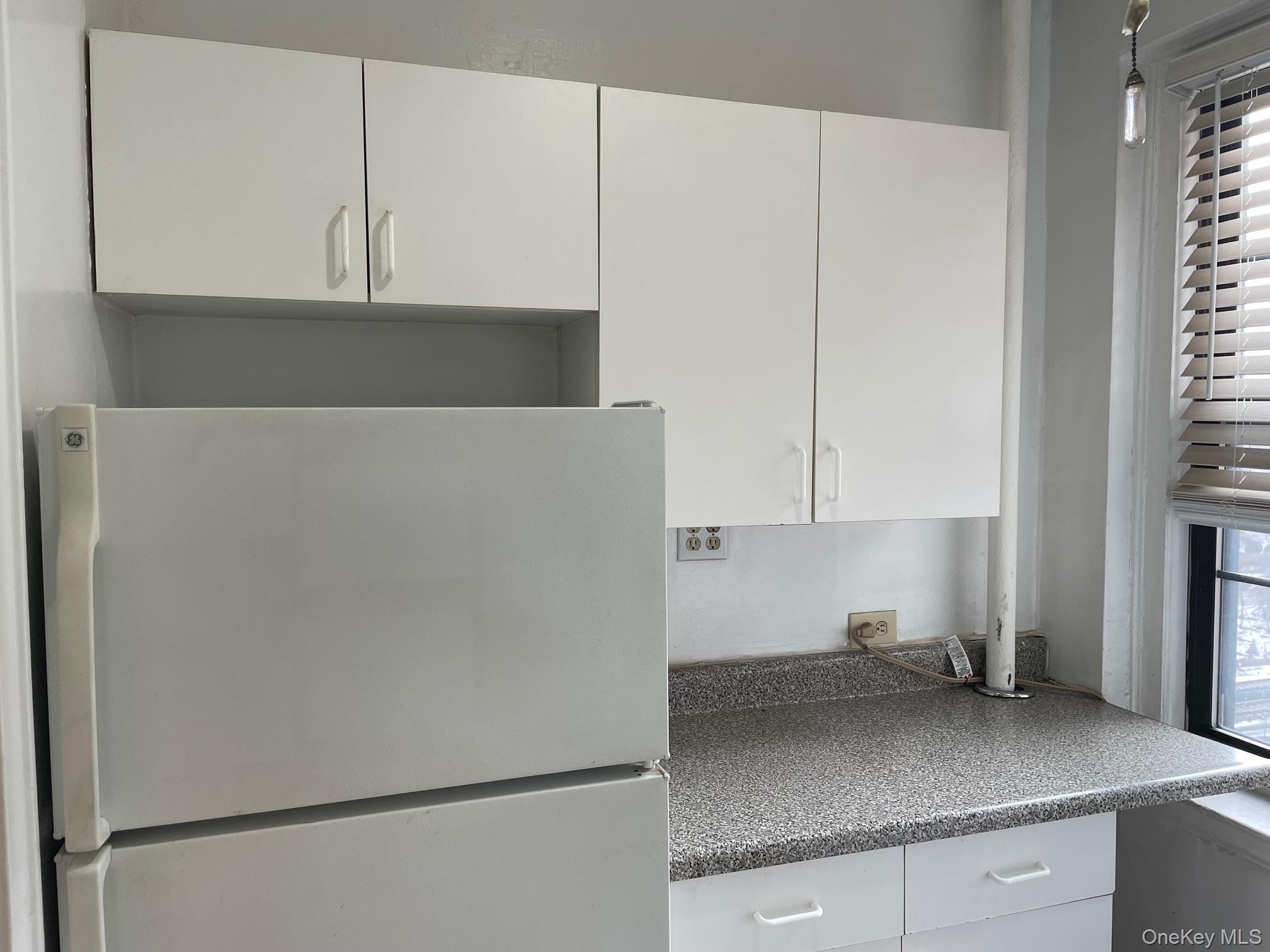 192 Garth Road, Unit 4N Scarsdale, NY 10583 - Photo 19 of 32 a kitchen with a refrigerator and cabinets