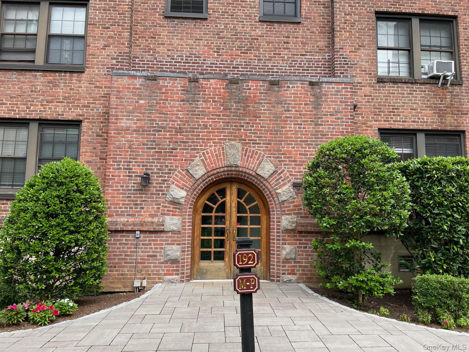 192 Garth Road, Unit 4N Scarsdale, NY 10583 - Photo 2 of 32 a front view of a house with a garden