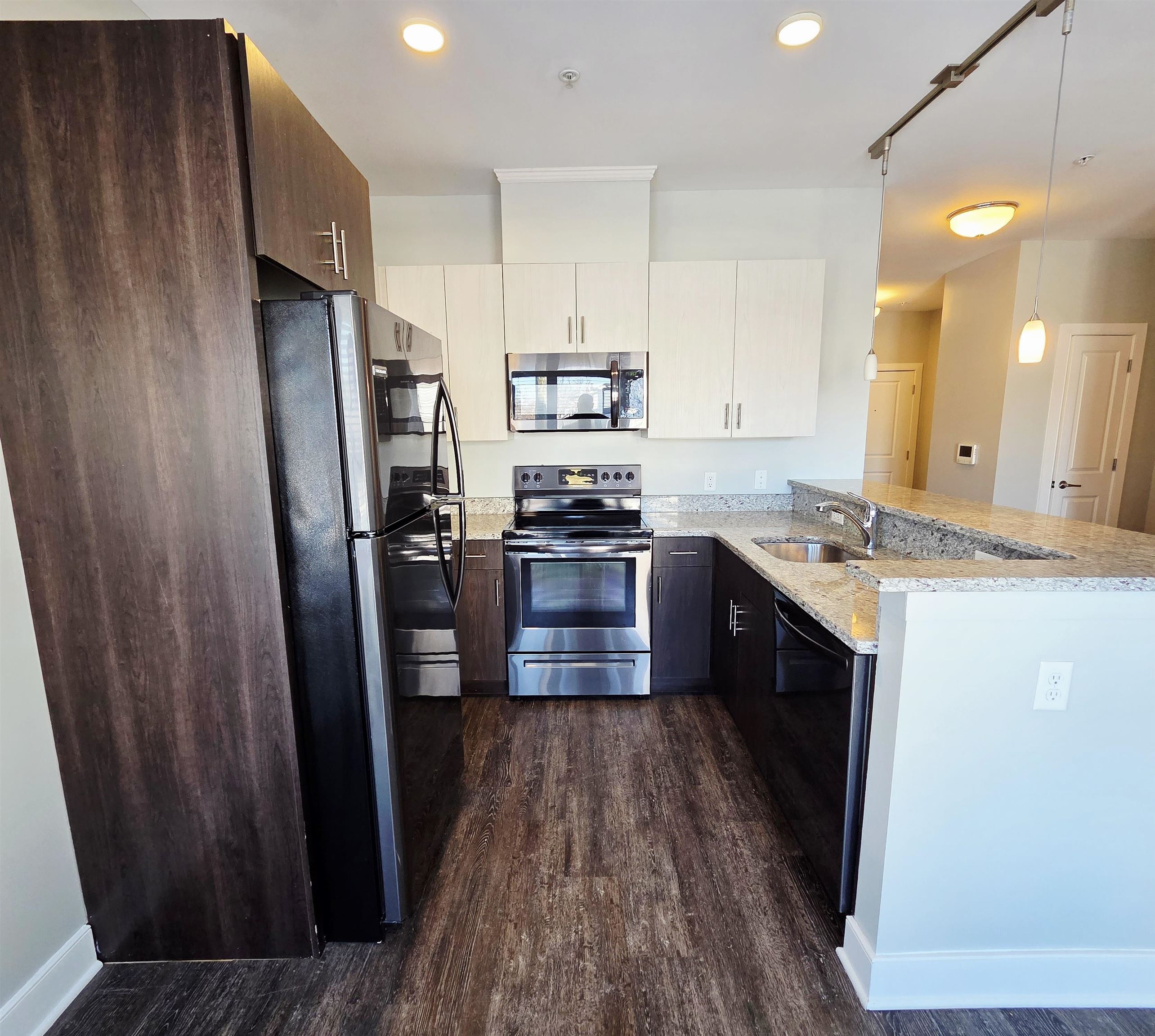 235 Ridge Road, Unit 1G North Arlington, NJ 07031 - Photo 5 of 13 a kitchen with stainless steel appliances a refrigerator and wooden floor