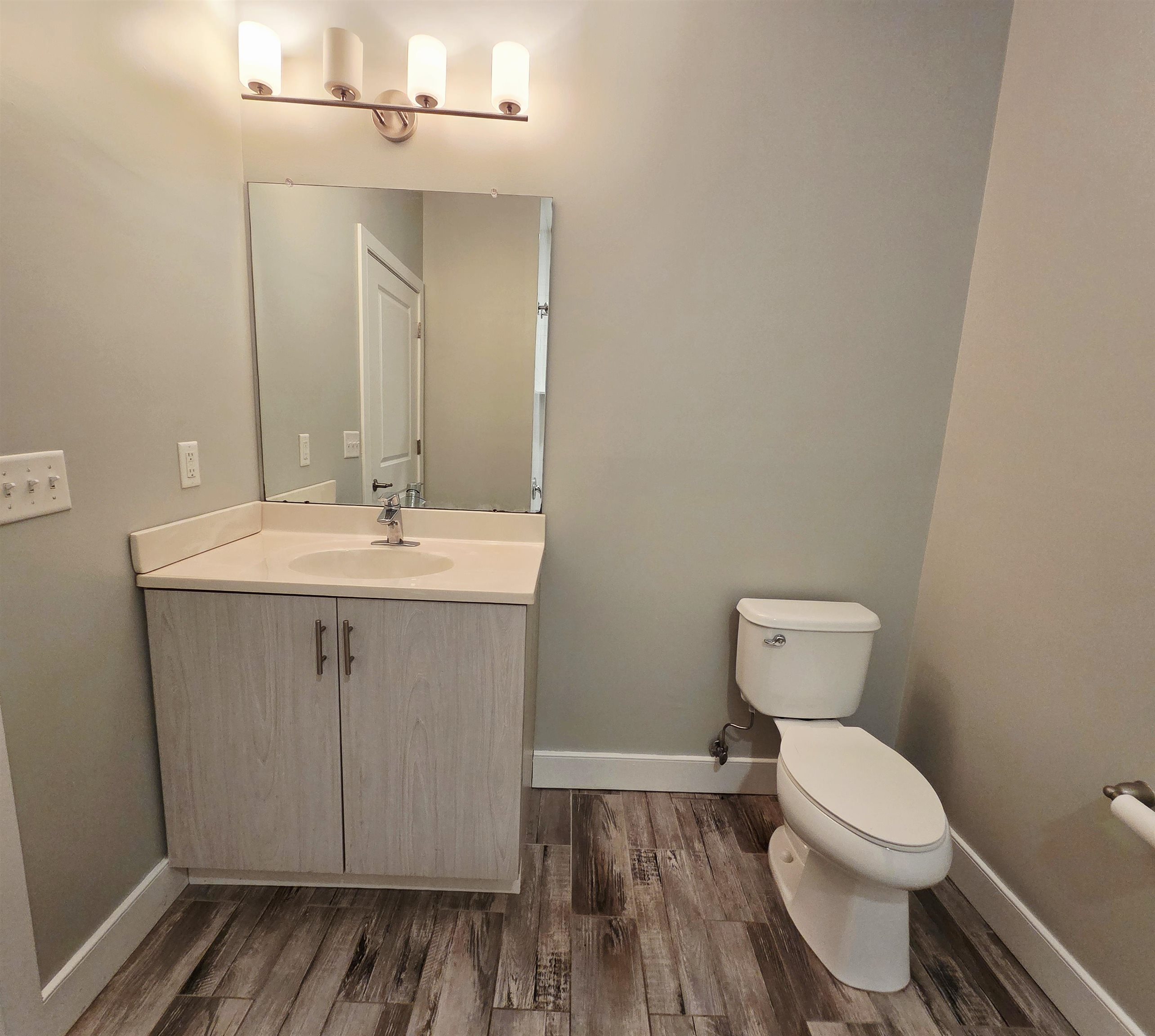 235 Ridge Road, Unit 1G North Arlington, NJ 07031 - Photo 9 of 13 a bathroom with a toilet a sink and wooden floor