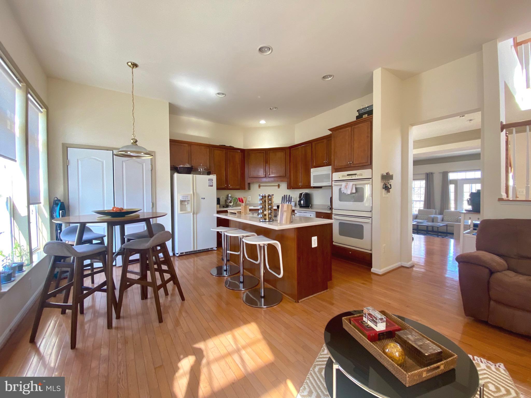 21975 Windover Drive Broadlands, VA 20148 - Photo 7 of 37 a living room with stainless steel appliances kitchen island granite countertop furniture and a wooden floor