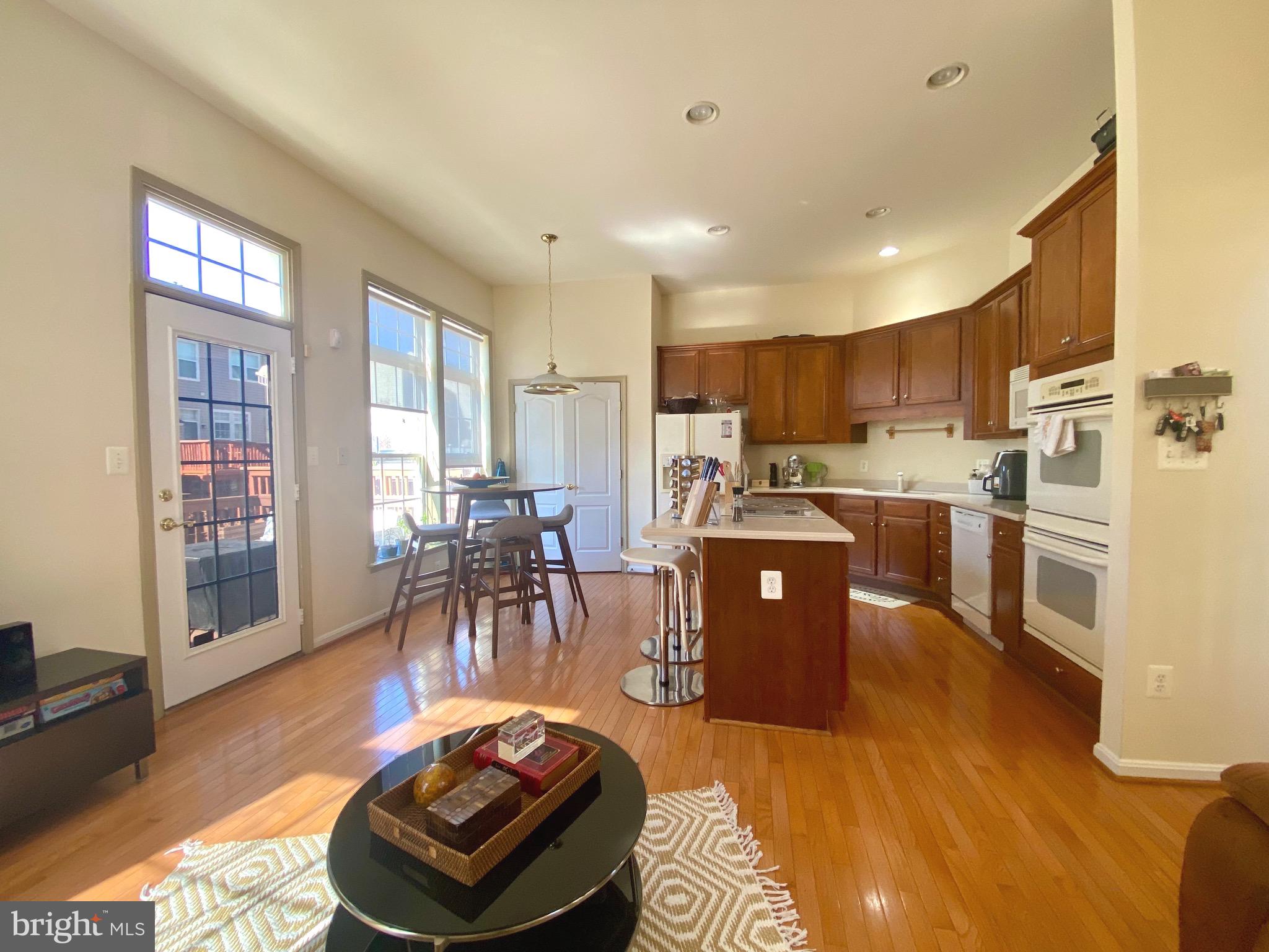 21975 Windover Drive Broadlands, VA 20148 - Photo 9 of 37 a living room with stainless steel appliances furniture wooden floor and a kitchen view