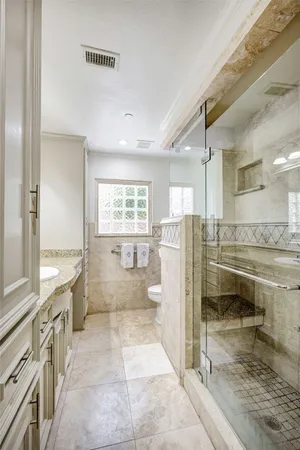 a bathroom with a double vanity sink toilet and shower