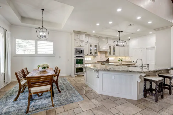 a dining room filled chandelier and kitchen view