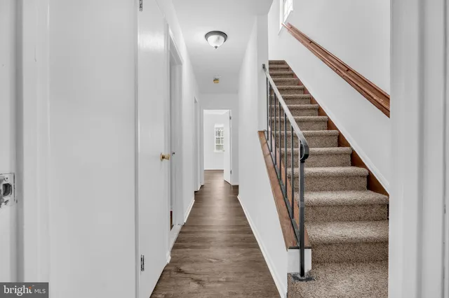 a view of a hallway with wooden floor and entryway