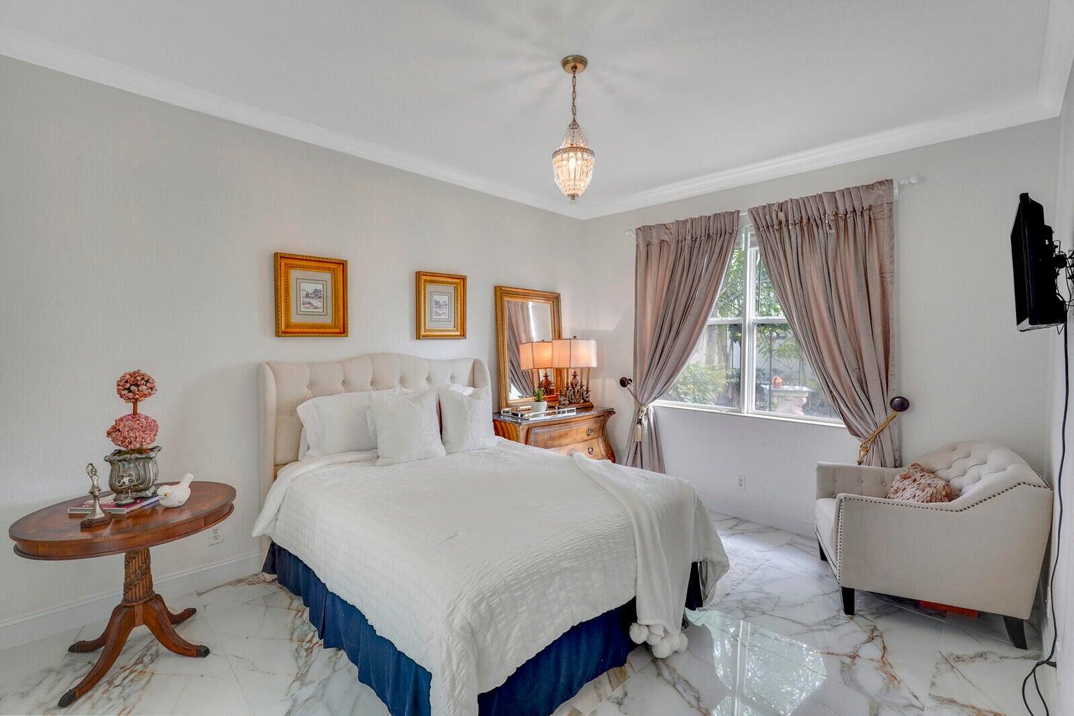 599 Cresta Circle West Palm Beach, FL 33413 - Photo 31 of 56 a bedroom with a bed and a chandelier