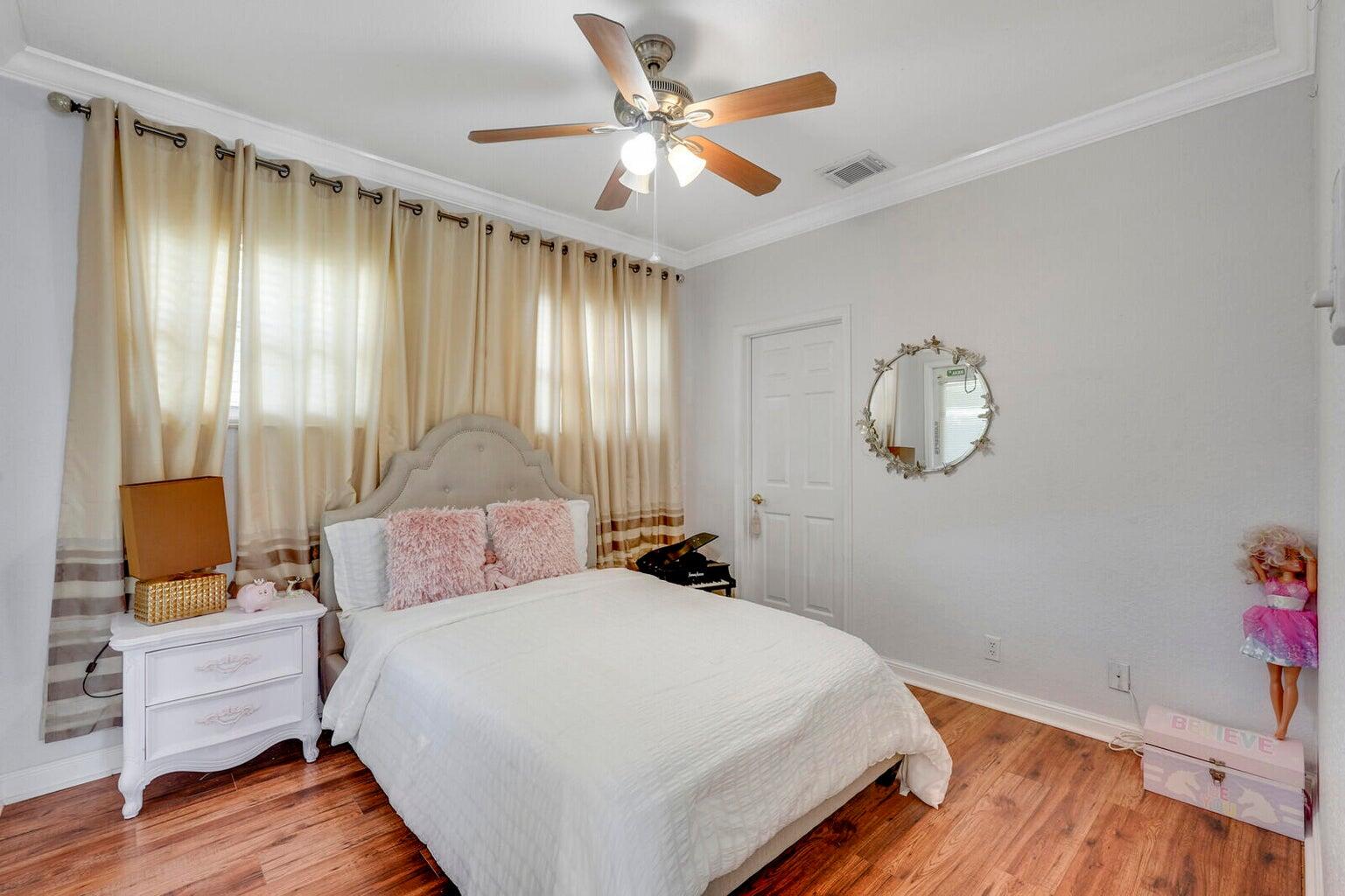 599 Cresta Circle West Palm Beach, FL 33413 - Photo 37 of 56 a bedroom with a bed and wooden floor