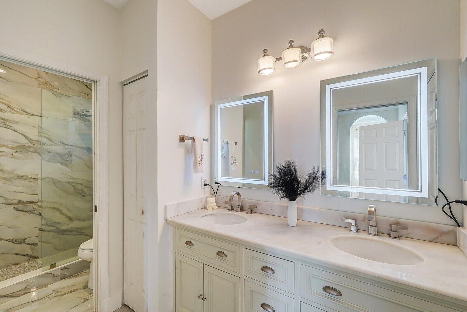 599 Cresta Circle West Palm Beach, FL 33413 - Photo 39 of 56 a bathroom with double vanity sinks a vanity a lamp and a mirror