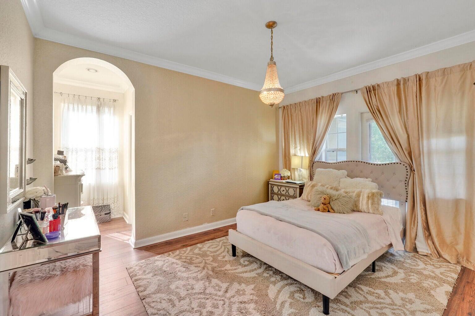 599 Cresta Circle West Palm Beach, FL 33413 - Photo 40 of 56 a bedroom with a bed and a chandelier