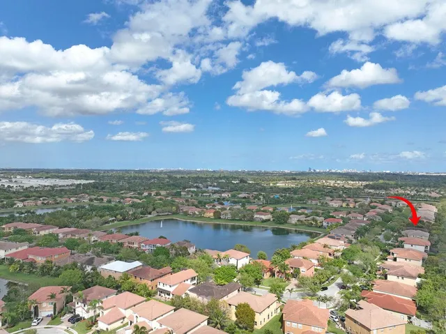 an aerial view of lake and residential houses with outdoor space and lake view in back