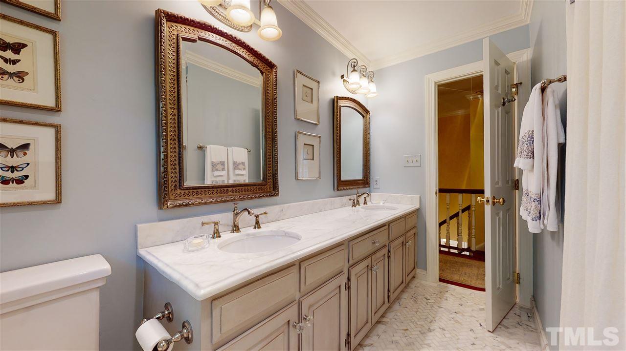 8817 Lomas Court Raleigh, NC 27615 - Photo 22 of 30 a en suite bathroom with a double vanity sink and a mirror