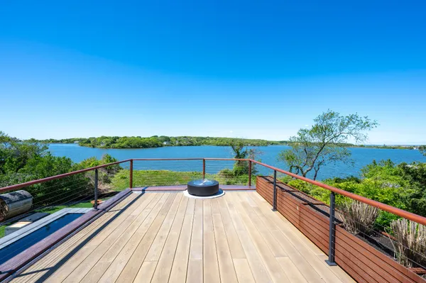 a view of a balcony with wooden floor and fence