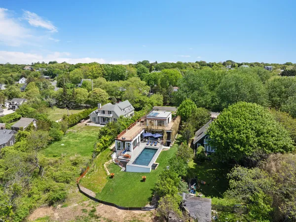 an aerial view of residential houses with outdoor space and trees