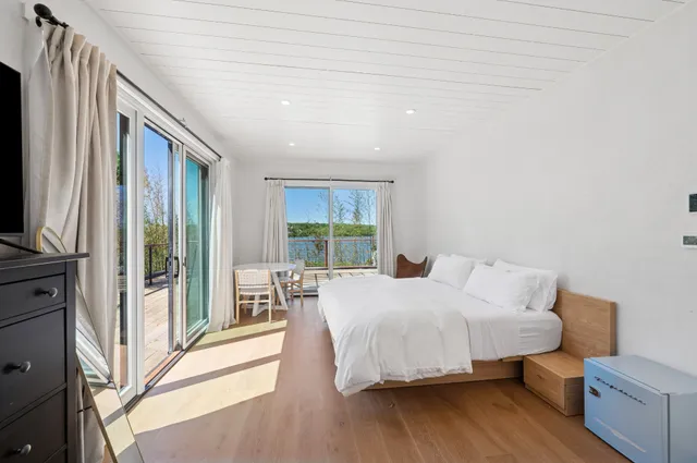 a bedroom with a bed and a flat tv screen on dresser