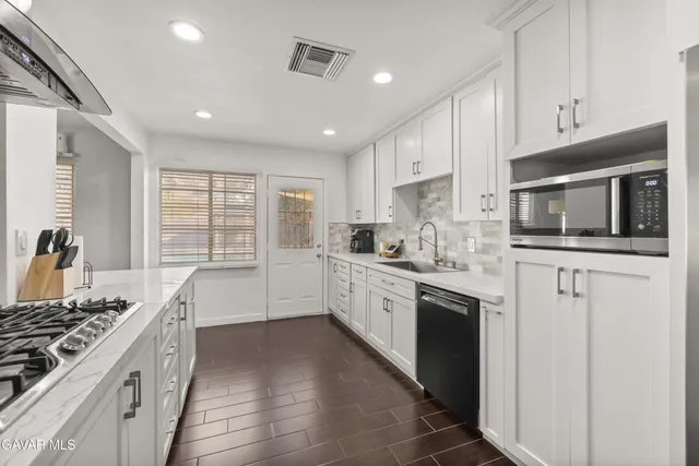 a large kitchen with stainless steel appliances granite countertop a stove and a sink