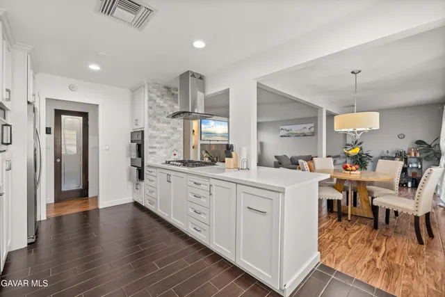 a large white kitchen with lots of counter space a sink and appliances