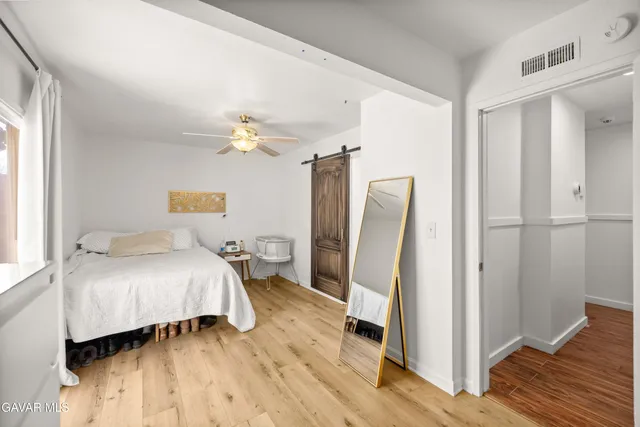 a bedroom with a bed dresser and a window