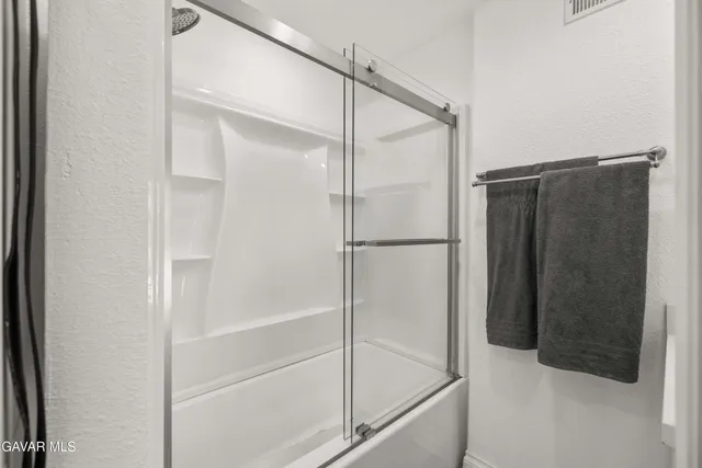 a bathroom with a glass shower door