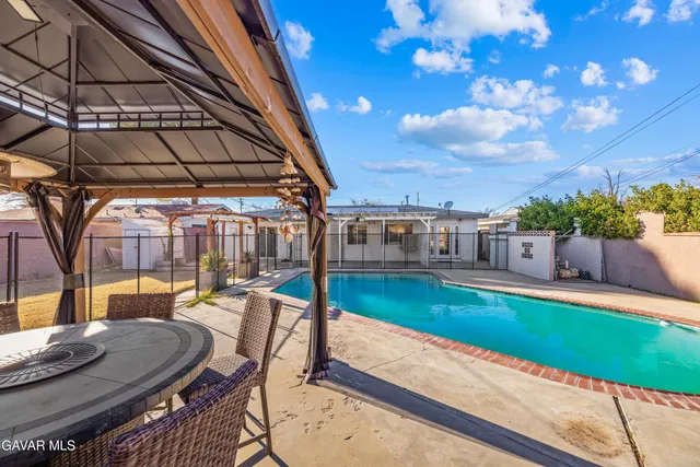 a patio with swimming pool table and chairs