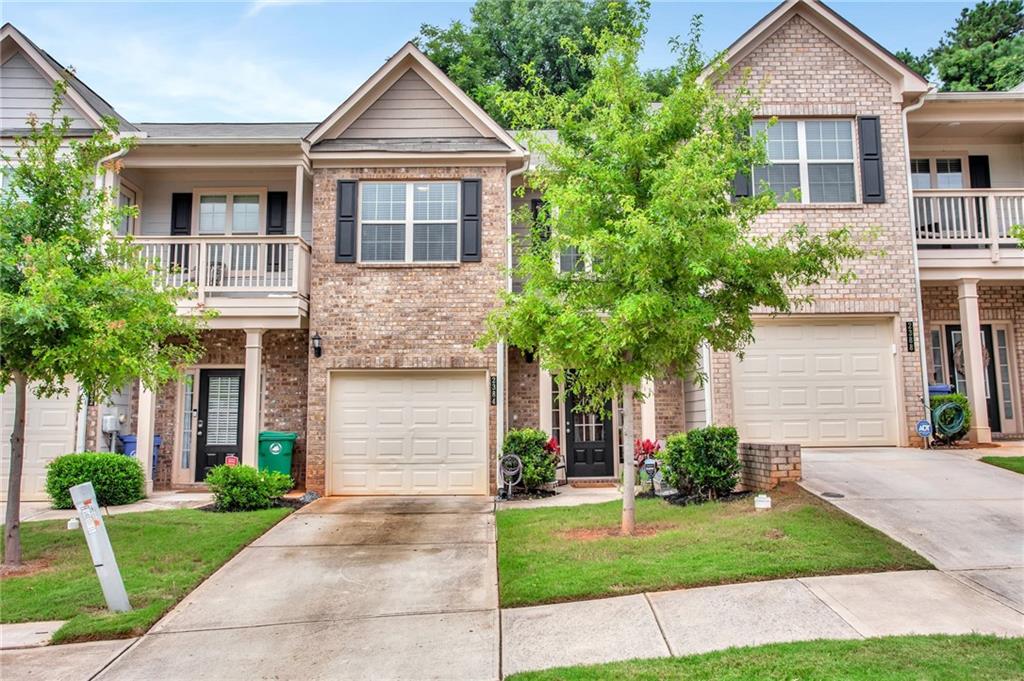 a front view of a house with a yard and potted plants