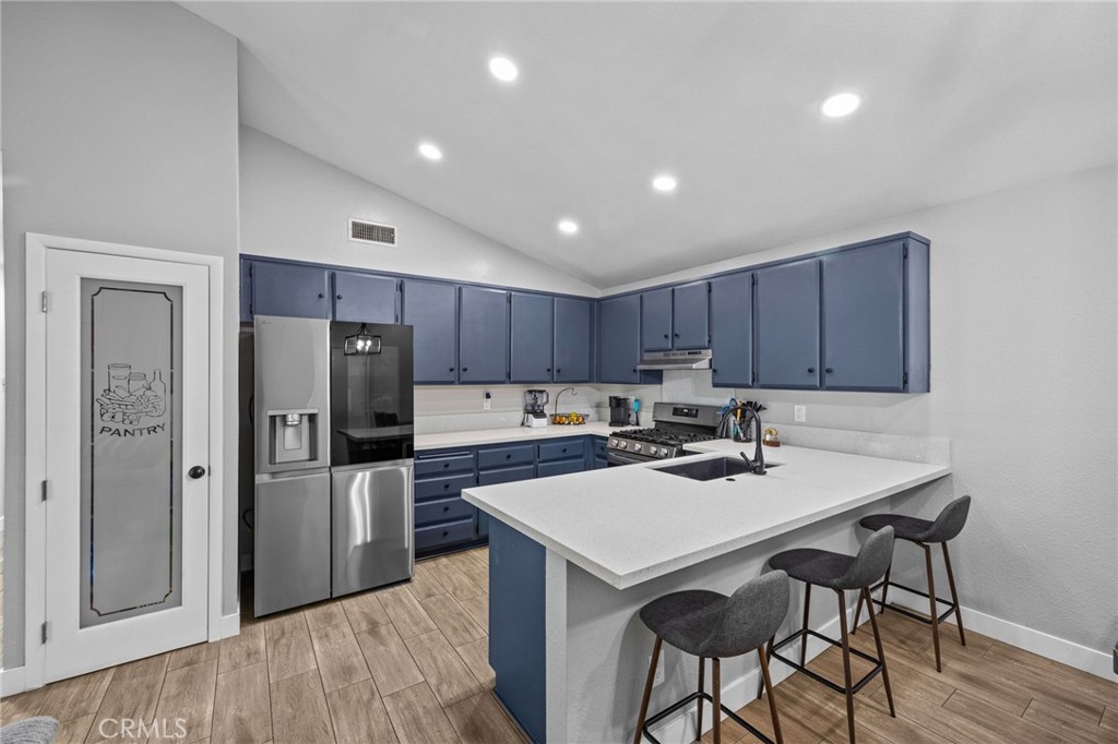 a kitchen with a refrigerator a stove a sink and a microwave with wooden floor