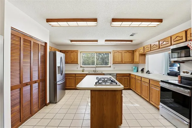 a kitchen with stainless steel appliances granite countertop a stove a sink dishwasher and a refrigerator