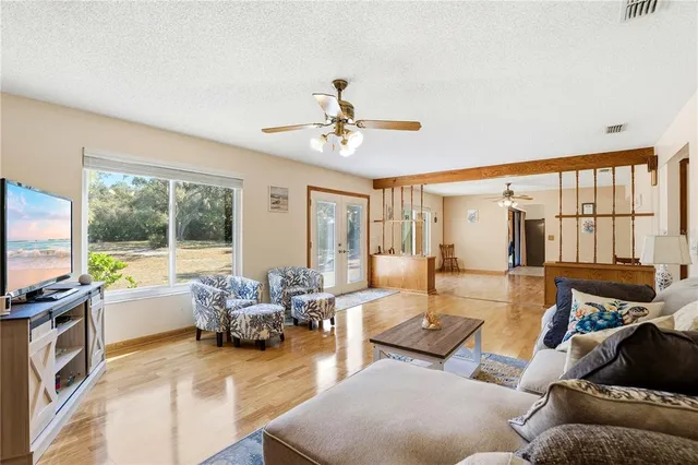 a living room with furniture a fireplace and a chandelier
