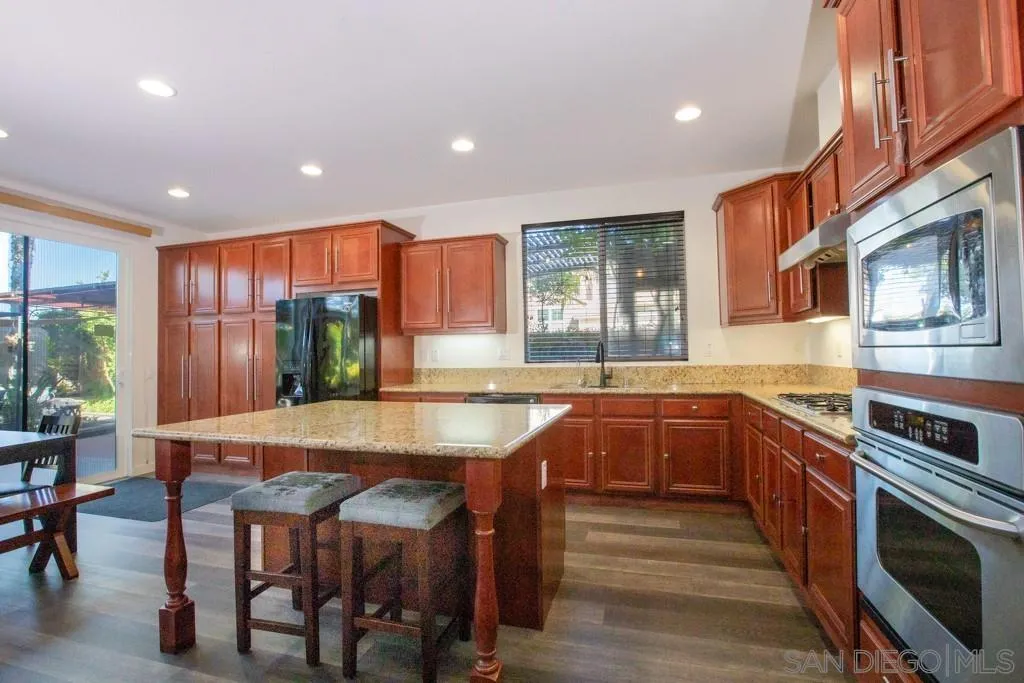 31340 Locust Court Temecula, CA 92592 - Photo 8 of 24 a kitchen with stainless steel appliances granite countertop table chairs sink and stove