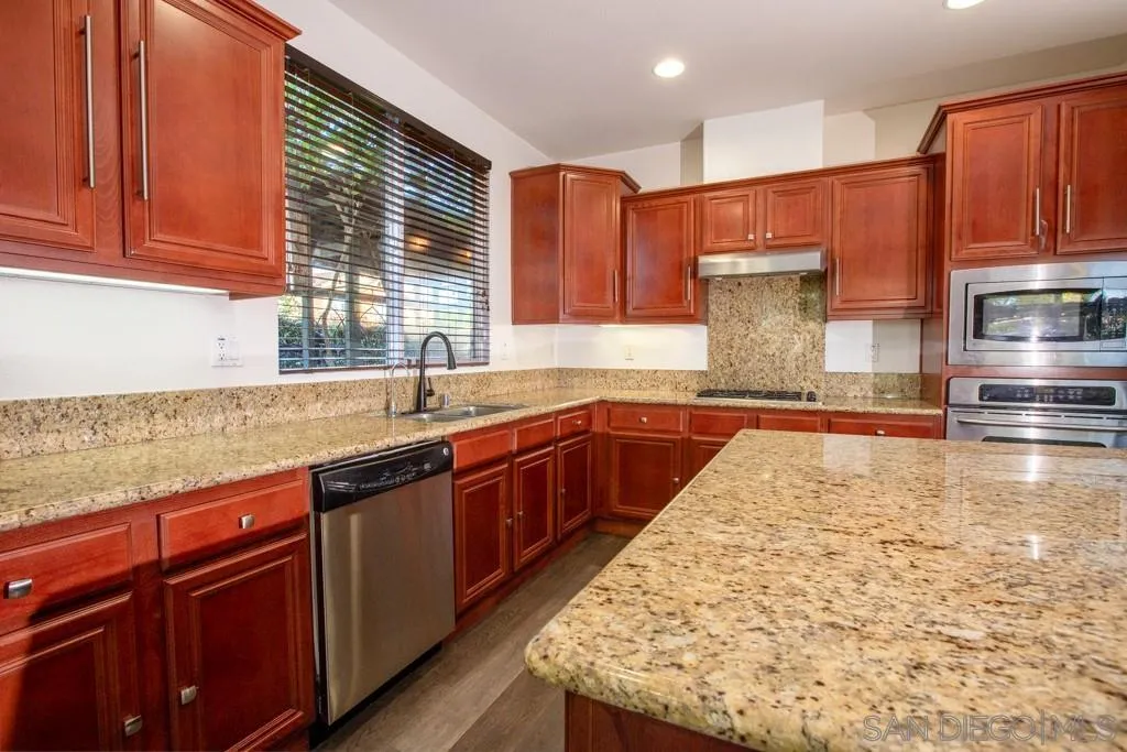 31340 Locust Court Temecula, CA 92592 - Photo 9 of 24 a kitchen with stainless steel appliances granite countertop wooden cabinets a sink and dishwasher