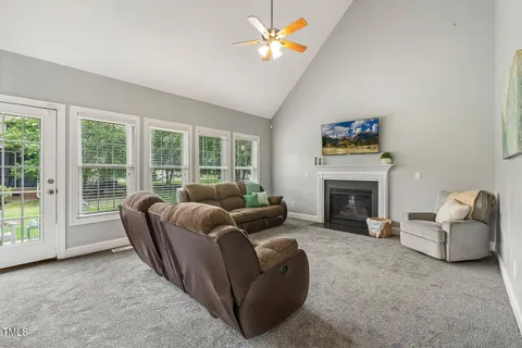 a living room with furniture a fireplace and a floor to ceiling window