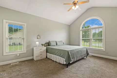 a spacious bedroom with a bed and a window