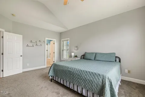 a bedroom with a bed and painting on the wall