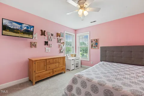 a spacious bedroom with a bed and a chandelier