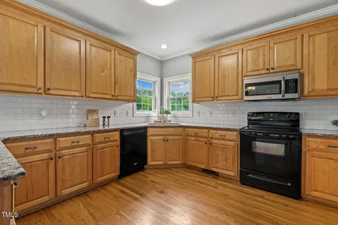 a kitchen with stainless steel appliances granite countertop a stove sink microwave and cabinets