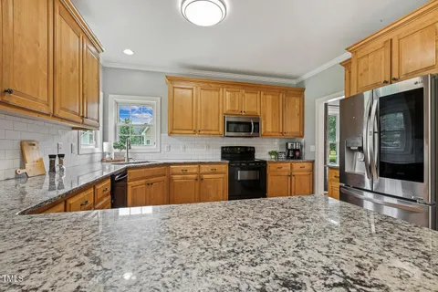 a kitchen with stainless steel appliances granite countertop a sink refrigerator and microwave