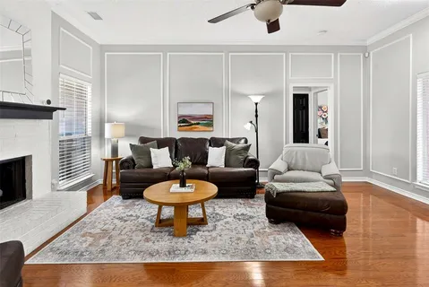 a living room with furniture a fireplace a flat screen tv and a window