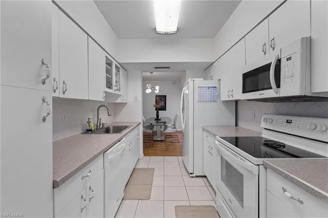 a kitchen with stainless steel appliances granite countertop a sink and dishwasher a stove top oven with white cabinets
