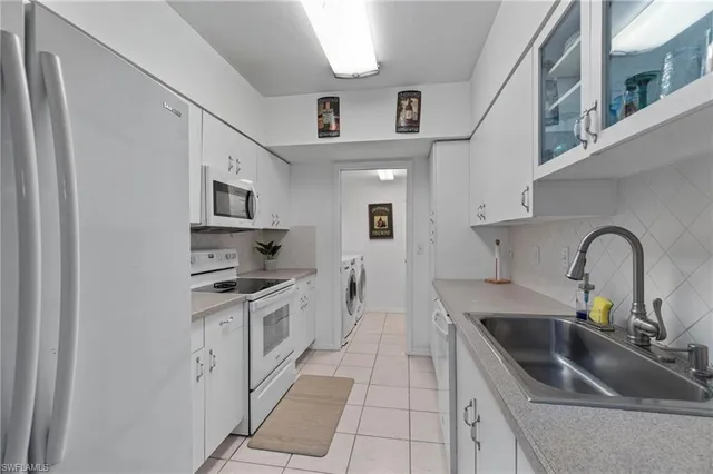 a kitchen with stainless steel appliances a sink a stove top oven a counter space and cabinets