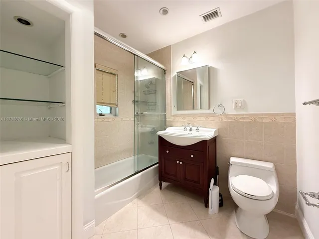 a bathroom with a toilet a sink a mirror and a shower