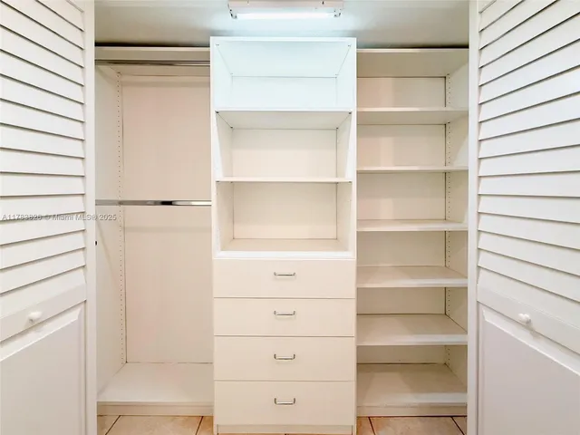 a view of walk in closet with empty racks