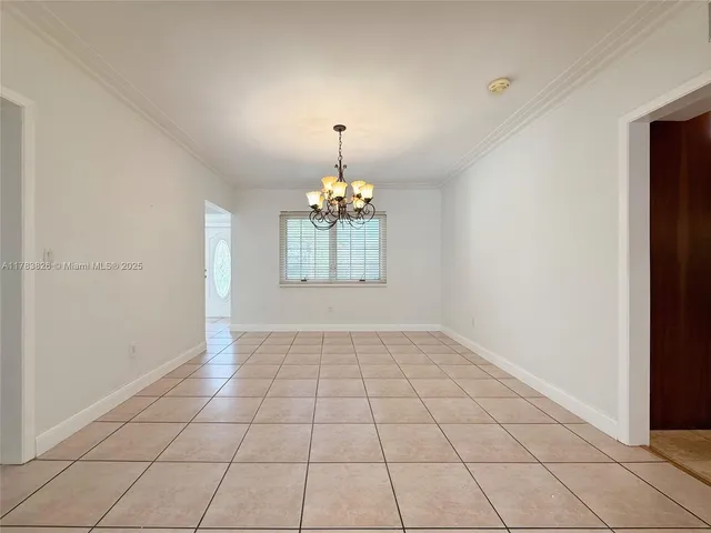 an empty room with windows and chandelier