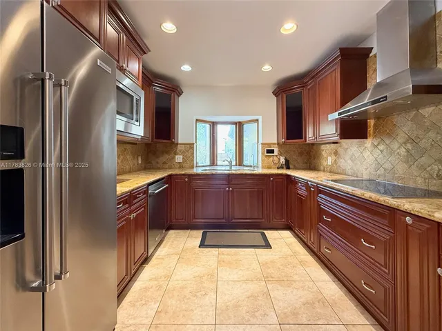 a kitchen with stainless steel appliances granite countertop a refrigerator and a sink