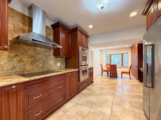 a large kitchen with stainless steel appliances granite countertop a sink and cabinets