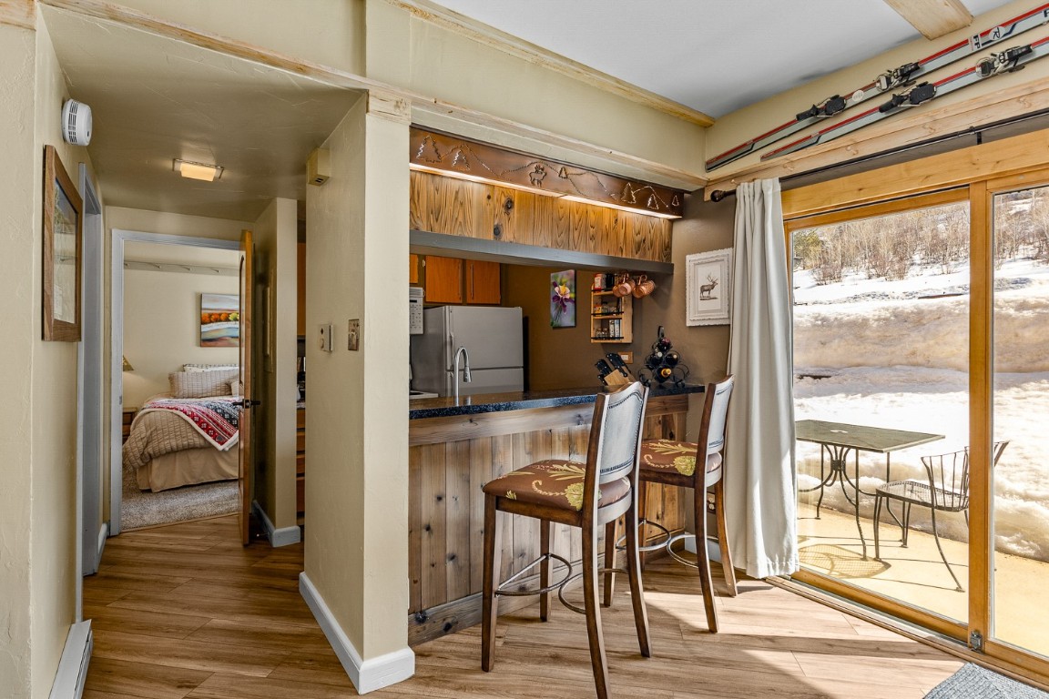 1945 Cornice Road, Unit 101D Steamboat Springs, CO 80487 - Photo 13 of 33 Bar with baseboards, bar area, light wood-style flooring, and freestanding refrigerator