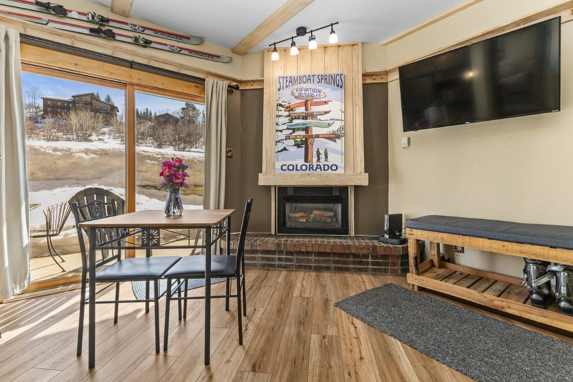 1945 Cornice Road, Unit 101D Steamboat Springs, CO 80487 - Photo 15 of 33 Dining area featuring a fireplace, track lighting, and wood finished floors