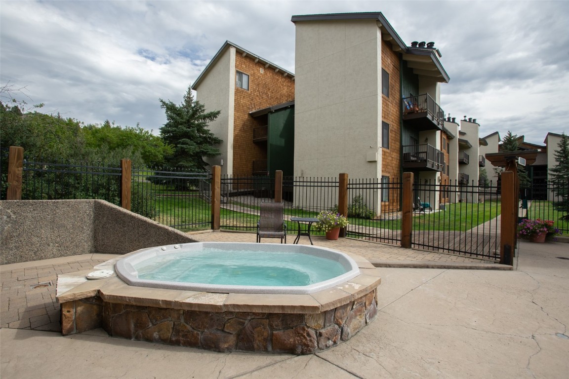 1945 Cornice Road, Unit 101D Steamboat Springs, CO 80487 - Photo 32 of 33 View of pool featuring an in ground hot tub and fence