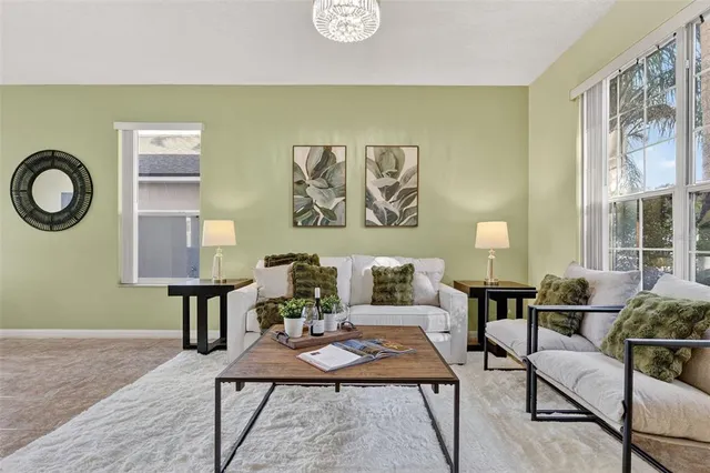 a kitchen with a stove a microwave and living room view