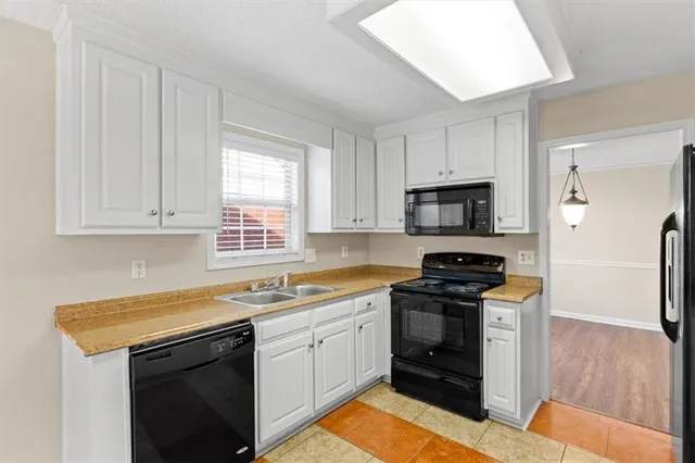 a kitchen with white cabinets stainless steel appliances and sink